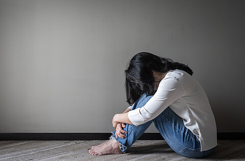 Frau mit Angststörung sitzt am Boden
